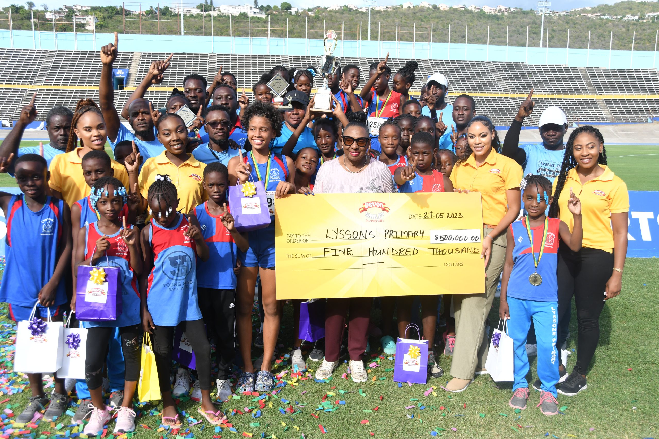 Minister of Culture, Gender, Entertainment and Sports, the Honourable Olivia Grange along with Devon Biscuits brand manager Sherene Bryan presented the INSPORTS/Devon Biscuits National Primary schools winning trophy to champions Lyssons Primary school.