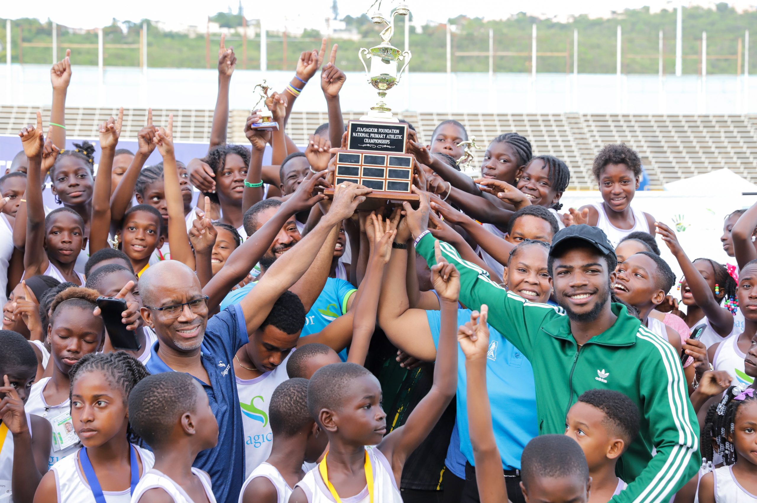 St. Elizabeth lifts the trophy after winning the 38th staging of the JTA/Sagicor National Athletic Championships. With them is Willard Brown, Chief Technology and Insurance Operations Officer, Sagicor Group Jamaica (left) and Bouwahjgie Nkrumie, patron and under 20 100m national record holder.
