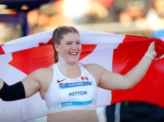 Canada's Sarah Mitton holds her country's flag aloft following her gold medal win in shot put on Day 4 of the Pan American Games.