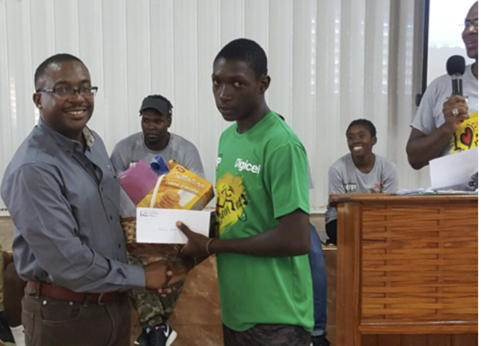Antonio Watson from Petersfield High School is honored with the NCB Boy of the Camp award at the MVP Grassroots Training Camp on Saturday, October 1, 2016. Pictured alongside him are Stuart Barnes from NCB and Bruce James, President of MVP, holding the microphone.